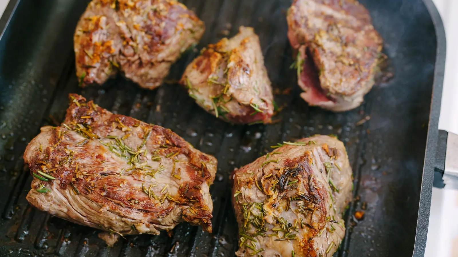 Steak wird in einer heißen Gusseisenpfanne scharf angebraten