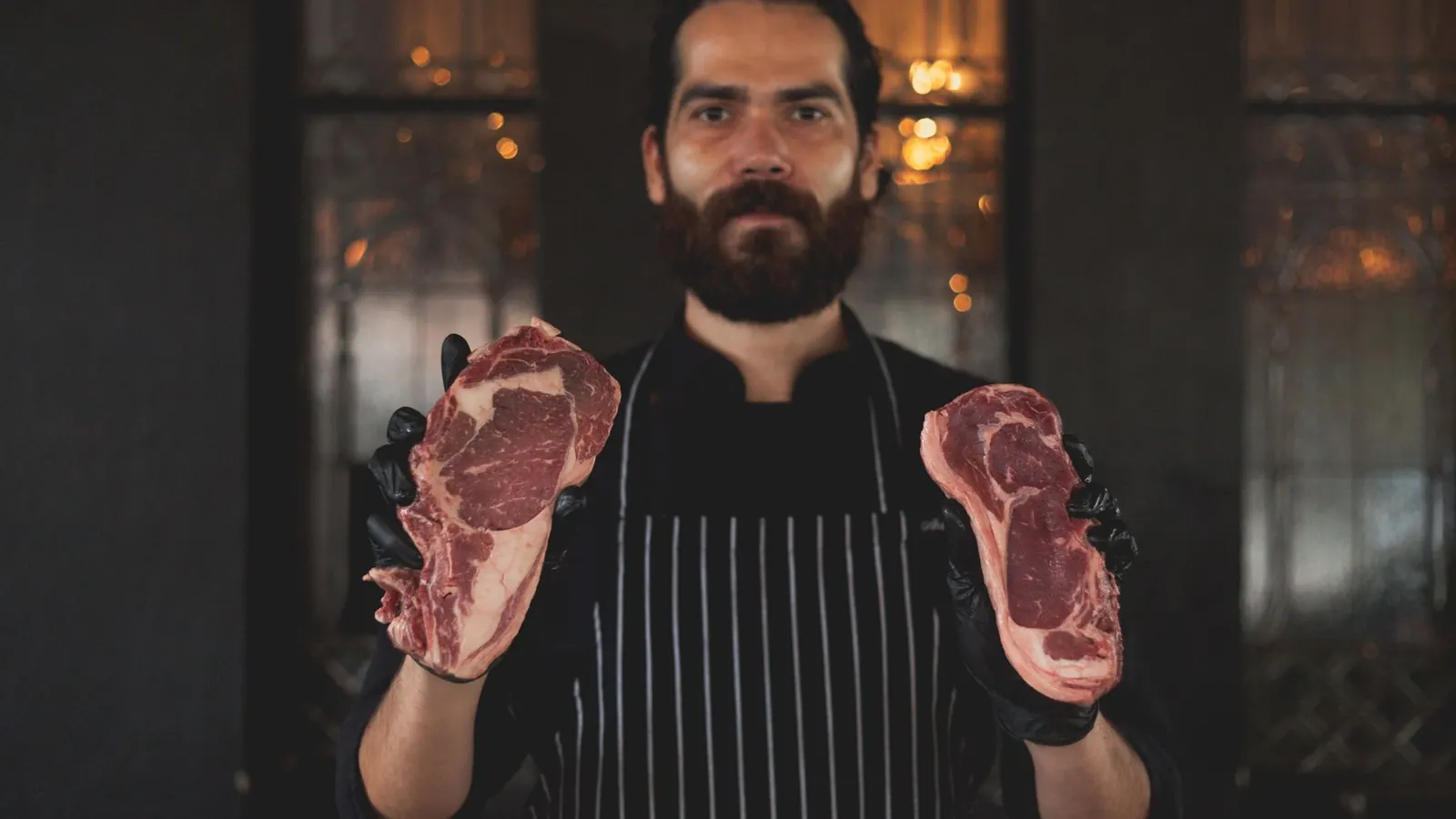 Rohes, gut marmoriertes Rindersteak mit Fettrand auf einem Schneidbrett
