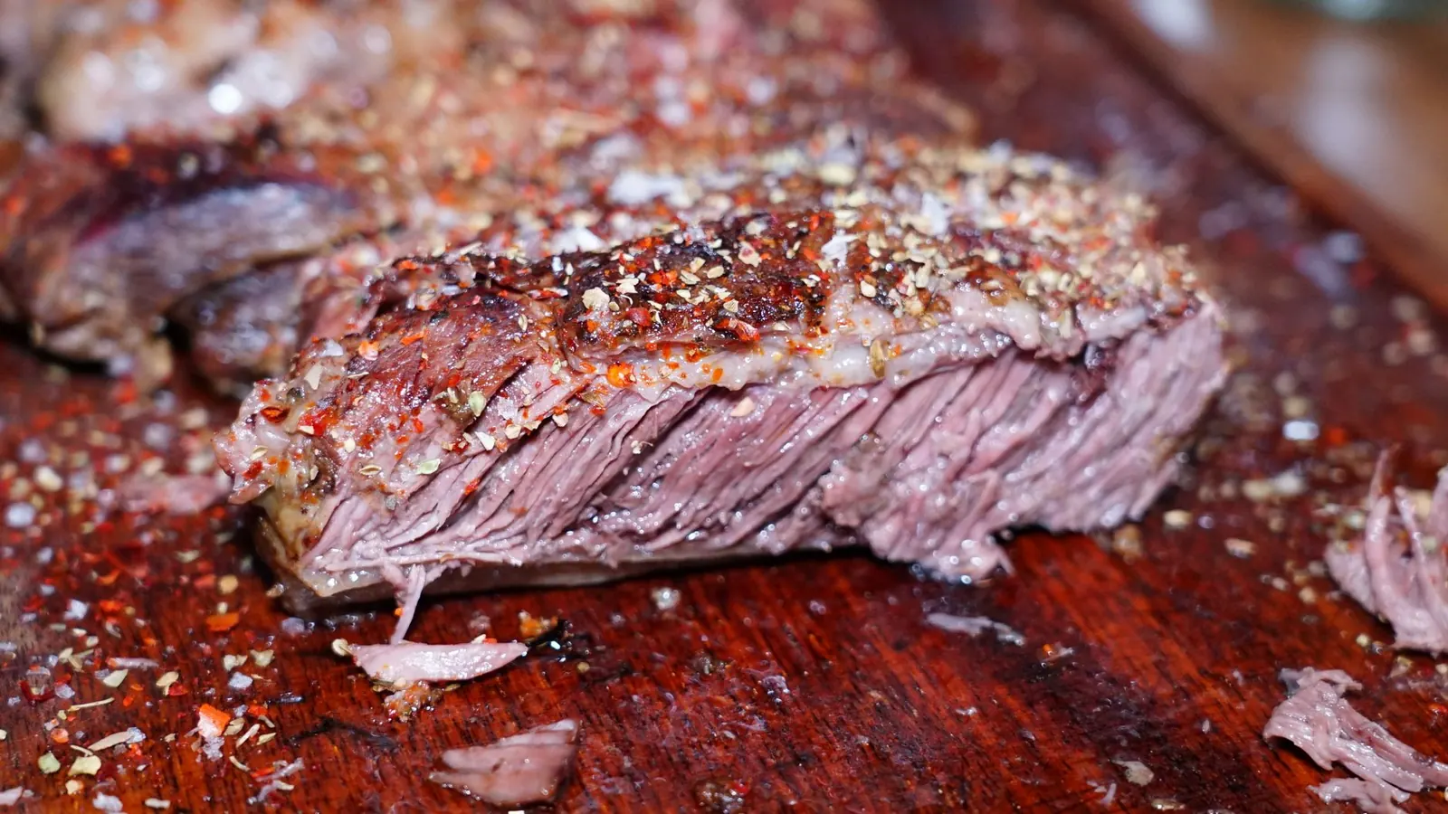 Aufgeschnittenes Steak auf dem Schneidebrett mit rosa Kern und gebräunter Kruste