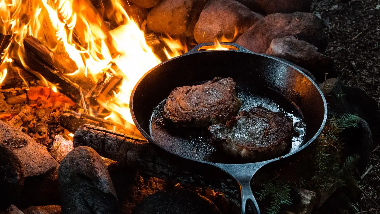 Gusseisenpfanne mit angebratenem Steak auf dem Herd