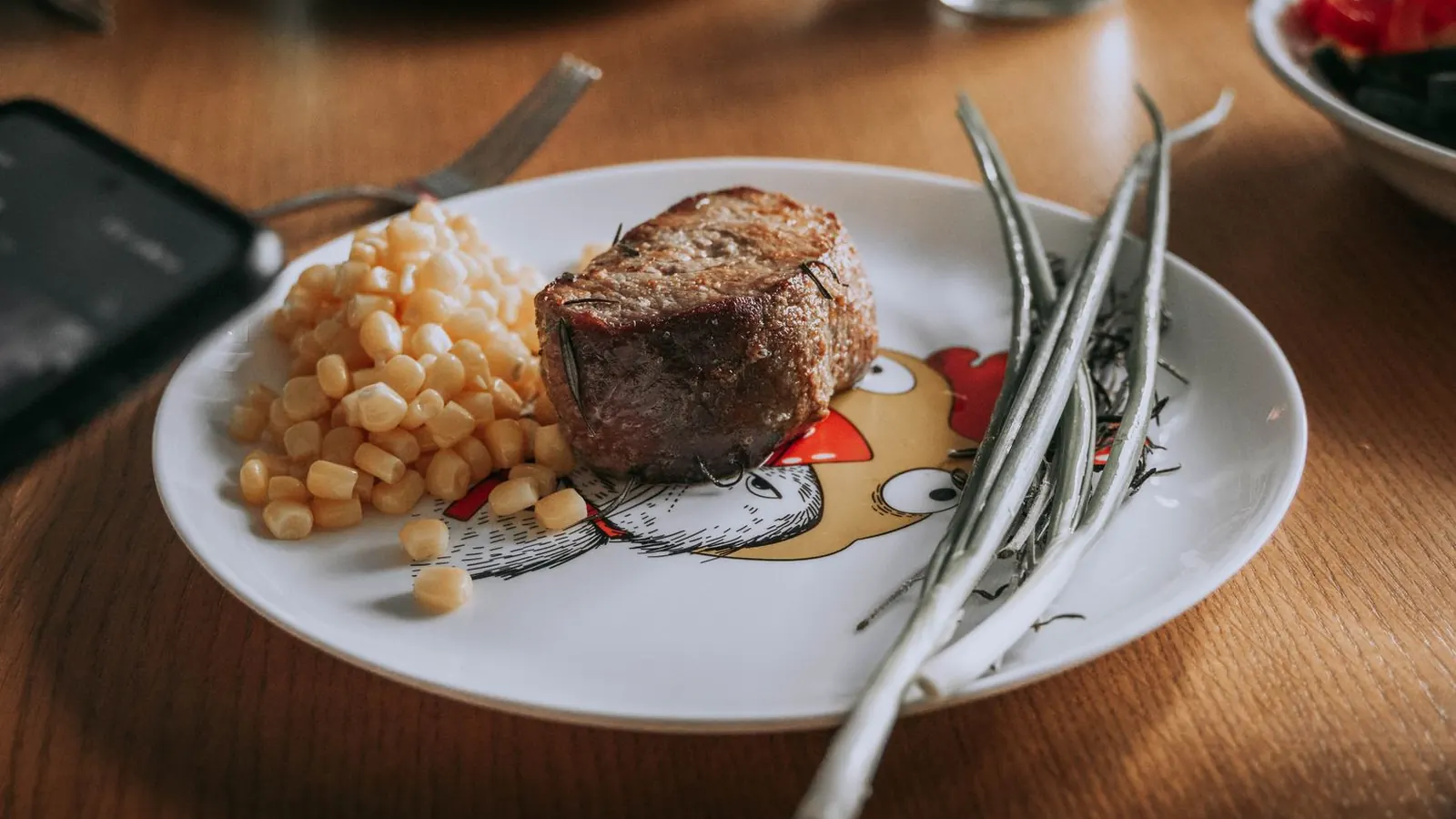 Fleischthermometer steckt in einem Steak auf einem Holzbrett